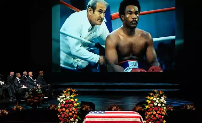 A photo of George Foreman sitting in the corner of a boxing ring is shown during a tribute video honoring Olympic and world champion boxer and minister Foreman during his memorial service at Wortham Theater Center in Houston, Monday, April 14, 2025. (Brett Coomer/Houston Chronicle via AP)