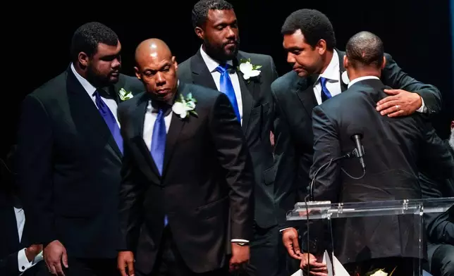 George Foreman IV, right embraces his brothers as they leave the stage following the eulogy for their father during a memorial service for Olympic and world champion boxer and minister George Foreman at Wortham Theater Center in Houston, Monday, April 14, 2025. (Brett Coomer/Houston Chronicle via AP)