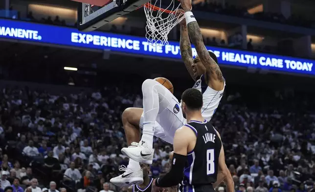 Dallas Mavericks forward P.J. Washington, center, dunks next to Sacramento Kings guard Zach LaVine (8) during the first half of an NBA play-in tournament basketball game Wednesday, April 16, 2025, in Sacramento, Calif. (AP Photo/Godofredo A. Vásquez)