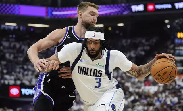 Dallas Mavericks forward Anthony Davis (3) moves the ball while defended by Sacramento Kings center Domantas Sabonis during the first half of an NBA play-in tournament basketball game Wednesday, April 16, 2025, in Sacramento, Calif. (AP Photo/Godofredo A. Vásquez)