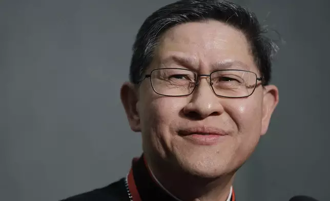 FILE - Cardinal Luis Tagle smiles as he listens reporters questions during a press conference on the Synod at the Vatican, Tuesday, Oct. 23, 2018. (AP Photo/Alessandra Tarantino, File)