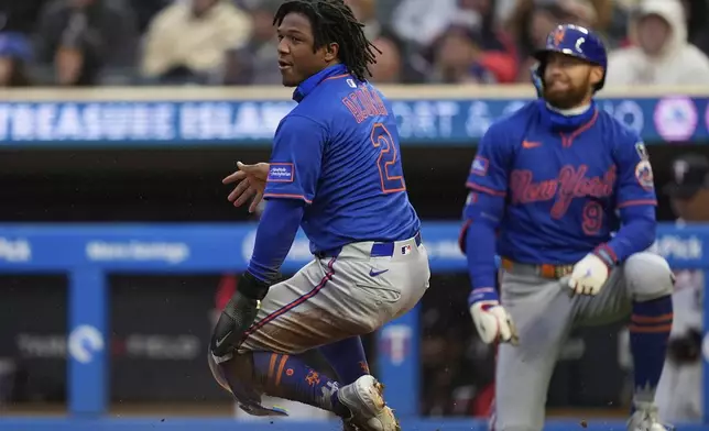 New York Mets' Luisangel Acuña (2) scores off an RBI-single by New York Mets' Pete Alonso (20) during the third inning of a baseball game against the Minnesota Twins, Monday, April 14, 2025, in Minneapolis. (AP Photo/Abbie Parr)