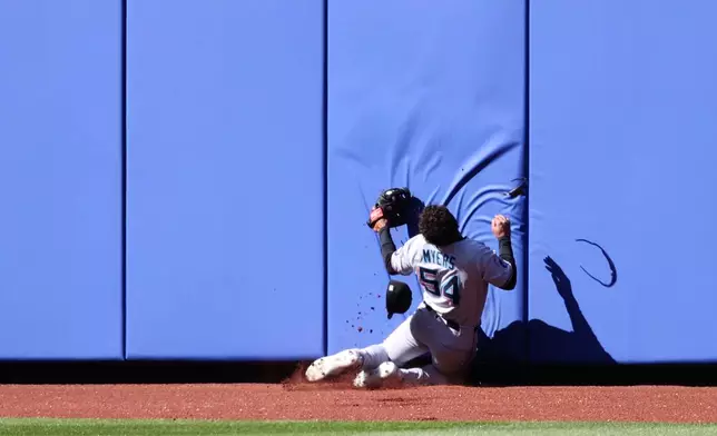 Miami Marlins' outfielder Dane Myers hits the wall after catching a flyball ball hit by New York Mets' Pete Alonso during the ninth inning of a baseball game, Wednesday, April 9, 2025, in New York. (AP Photo/Pamela Smith)