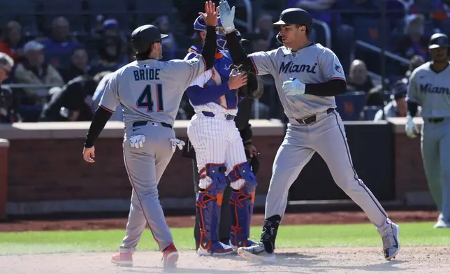 Miami Marlins' Matt Mervis, right, is greeted by Jonah Bride, left, after hitting a home run in the ninth inning of a baseball game against the New York Mets, Wednesday, April 9, 2025, in New York. (AP Photo/Pamela Smith)