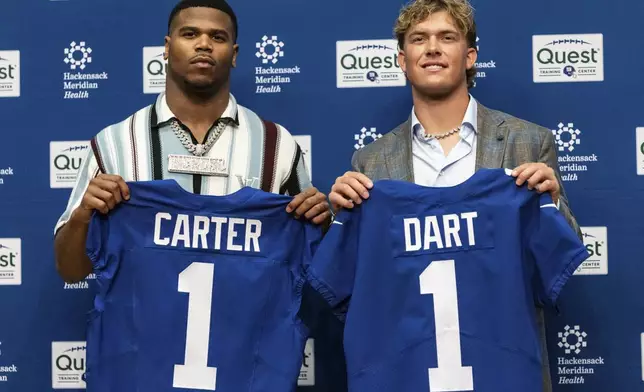 New York Giants' first round draft picks Abdul Carter and Jaxson Dart pose with shirts at an NFL football press conference at the team's training center in East Rutherford, N.J., Friday, April 25, 2025. (AP Photo/Stefan Jeremiah)