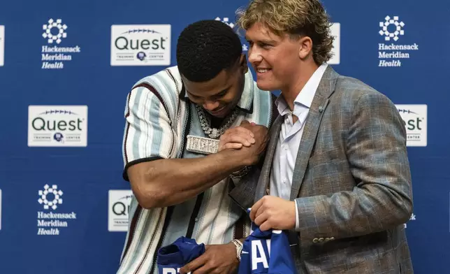 New York Giants first round draft picks Abdul Carter, left, and Jaxson Dart shake hands during an NFL football press conference at the team's training facility in East Rutherford, N.J., Friday, April 25, 2025. (AP Photo/Stefan Jeremiah)