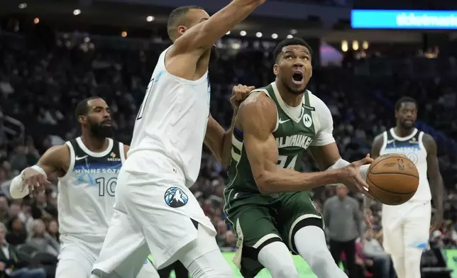 Milwaukee Bucks' Giannis Antetokounmpo drives to the basket against Minnesota Timberwolves' Rudy Gobert during the first half of an NBA basketball game Tuesday, April 8, 2025, in Milwaukee. (AP Photo/Aaron Gash)