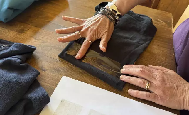 Rachael Z. Miller, founder of the Vermont-based Rozalia Project for a Clean Ocean, conducts a tape test on various clothing items to compare how much each material sheds microfibers on Thursday, April 17, 2025, in Granville, Vt. (AP Photo/Amanda Swinhart)