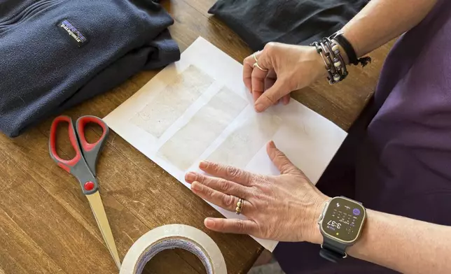 Rachael Z. Miller, founder of the Vermont-based Rozalia Project for a Clean Ocean, conducts a tape test on various clothing items to compare how much each material sheds microfibers on Thursday, April 17, 2025, in Granville, Vt. (AP Photo/Amanda Swinhart)