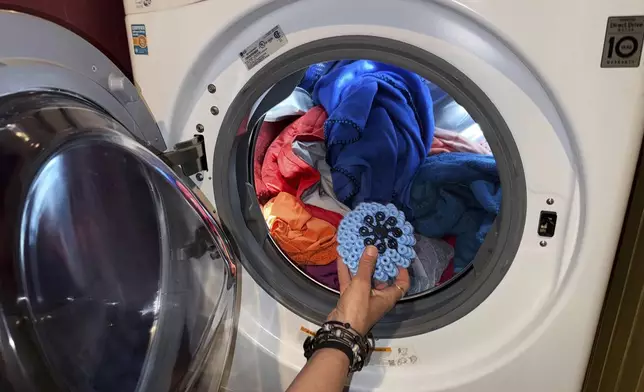 Rachael Z. Miller, founder of the Vermont-based Rozalia Project for a Clean Ocean, tosses a Cora Ball, a laundry ball that can be tossed into the washer to cut down on clothes banging into each other, on Thursday, April 17, 2025, in Granville, Vt. (AP Photo/Amanda Swinhart)