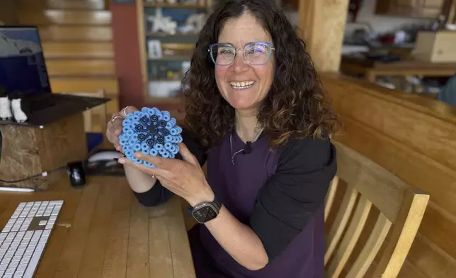 Rachael Z. Miller, founder of the Vermont-based Rozalia Project for a Clean Ocean, displays a Cora Ball, a laundry ball that can be tossed into the washer to cut down on clothes banging into each other and also catches microfibers, on Thursday, April 17, 2025, in Granville, Vt. (AP Photo/Amanda Swinhart)