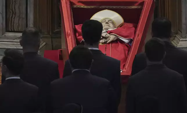 Vatican personnel pay their respects to Pope Francis inside St. Peter's Basilica at the Vatican, Wednesday, April 23, 2025, where his body will lie in state for three days. (AP Photo/Andrew Medichini, Pool)