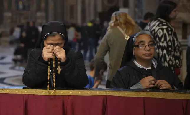 Nuns pray inside St. Peter's Basilica where Pope Francis is lying in state, at the Vatican, Thursday, April 24, 2025. (AP Photo/Alessandra Tarantino)