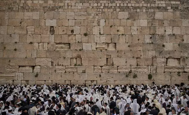 Covered in prayer shawls, Jewish men of the Cohanim Priestly caste participate in a blessing during the holiday of Passover, at the Western Wall, the holiest site where Jews can pray, in the Old City of Jerusalem, Tuesday, April 15, 2025. (AP Photo/Leo Correa)
