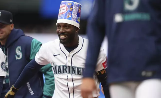 Seattle Mariners' Randy Arozarena wears a gum bucket to celebrate after his game-winning, bases-loaded walk for a 7-6 win over the Houston Astros in a baseball game Wednesday, April 9, 2025, in Seattle. (AP Photo/Lindsey Wasson)