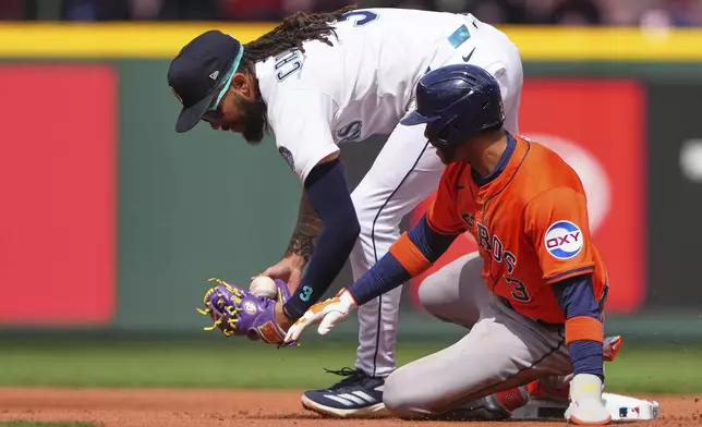 Houston Astros' Jeremy Peña (3) is safe at second as Seattle Mariners shortstop J.P. Crawford, left, can't make the tag on an error by starting pitcher Luis F. Castillo of a baseball game Wednesday, April 9, 2025, in Seattle. (AP Photo/Lindsey Wasson)