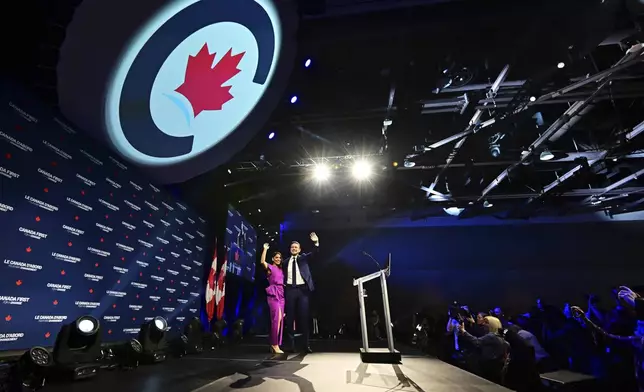Conservative Leader Pierre Poilievre and his wife Anaida Poilievre arrive on stage at his campaign headquarters on election night, in Ottawa, Tuesday, April 29, 2025.(Spencer Colby/The Canadian Press via AP)