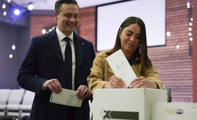 Conservative Leader Pierre Poilievre, left, looks on as his swife Anaida Poilievre casts her vote in the federal election in Ottawa, Canada, Monday, April 28, 2025 in Ottawa. (Adrian Wyld/The Canadian Press via AP)