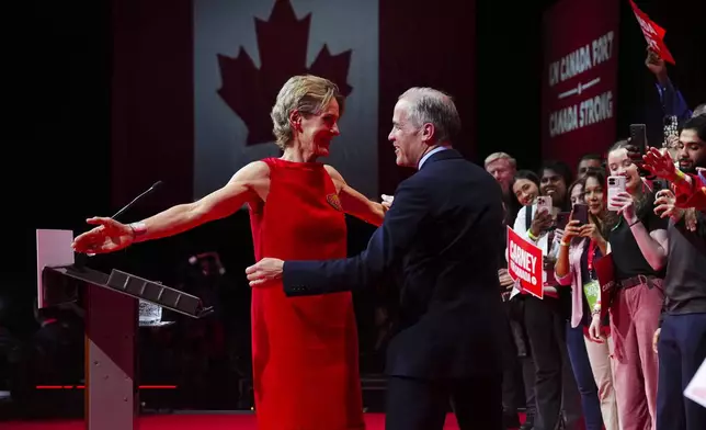 Canadian Prime Minister Mark Carney reacts with wife Diana Fox Carney on stage at his campaign headquarters after the Liberal Party won the Canadian election in Ottawa on Tuesday, April 29, 2025. (Sean Kilpatrick/The Canadian Press via AP)