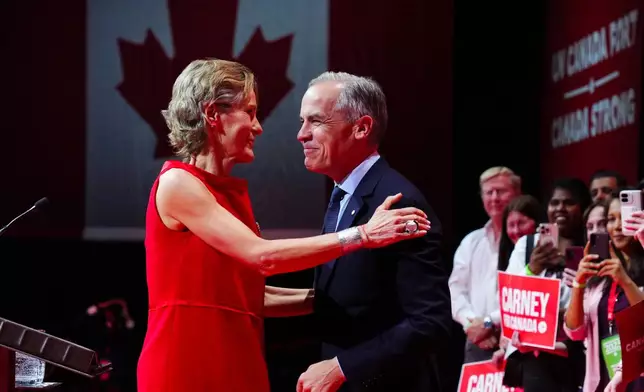 Canadian Prime Minister Mark Carney reacts with wife Diana Fox Carney on stage at his campaign headquarters after the Liberal Party won the Canadian election in Ottawa on Tuesday, April 29, 2025. (Sean Kilpatrick/The Canadian Press via AP)
