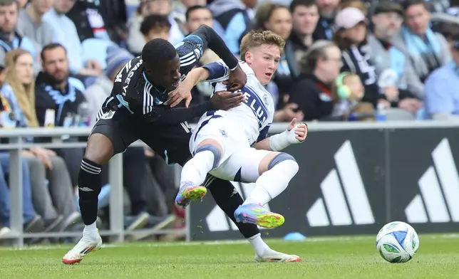 Minnesota United forward Tani Oluwaseyi, left, battles Vancouver Whitecaps defender Tate Johnson, right, during the second half of an MLS soccer match Sunday, April 27, 2025, in St. Paul, Minn. (AP Photo/Adam Bettcher)