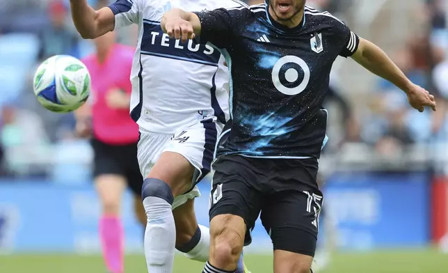 Vancouver Whitecaps forward Daniel Ríos, left, and Minnesota United defender Michael Boxall, right, chase the ball during the first half of an MLS soccer match Sunday, April 27, 2025, in St. Paul, Minn. (AP Photo/Adam Bettcher)