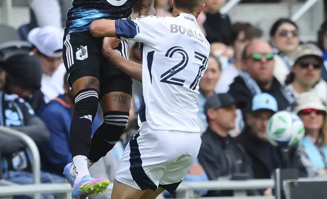 Minnesota United midfielder Joseph Rosales, top, heads the ball over Vancouver Whitecaps defender Giuseppe Bovalina (27) during the first half of an MLS soccer match Sunday, April 27, 2025, in St. Paul, Minn. (AP Photo/Adam Bettcher)