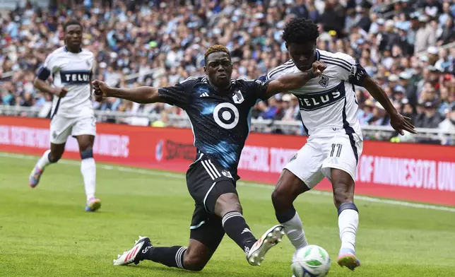 Minnesota United forward Bongokuhle Hlongwane, front left, and Vancouver Whitecaps forward Emmanuel Sabbi (11) battle for the ball during the first half of an MLS soccer match Sunday, April 27, 2025, in St. Paul, Minn. (AP Photo/Adam Bettcher)