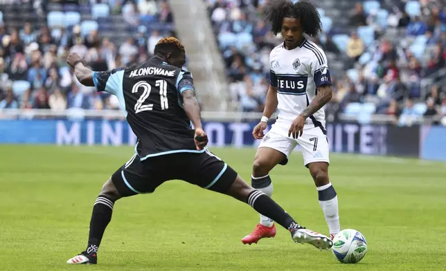 Minnesota United forward Bongokuhle Hlongwane (21) blocks a pass by Vancouver Whitecaps forward Jayden Nelson (7) during the first half of an MLS soccer match Sunday, April 27, 2025, in St. Paul, Minn. (AP Photo/Adam Bettcher)