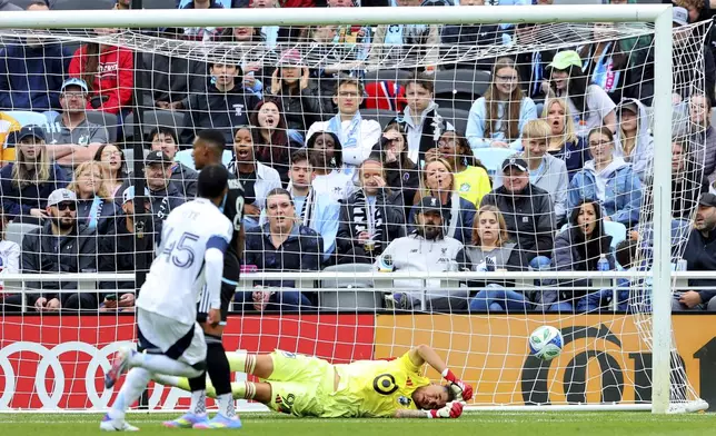 Vancouver Whitecaps midfielder Pedro Vite (45) scores against Minnesota United goalkeeper Dayne St. Clair, right, during the second half of an MLS soccer match Sunday, April 27, 2025, in St. Paul, Minn. (AP Photo/Adam Bettcher)
