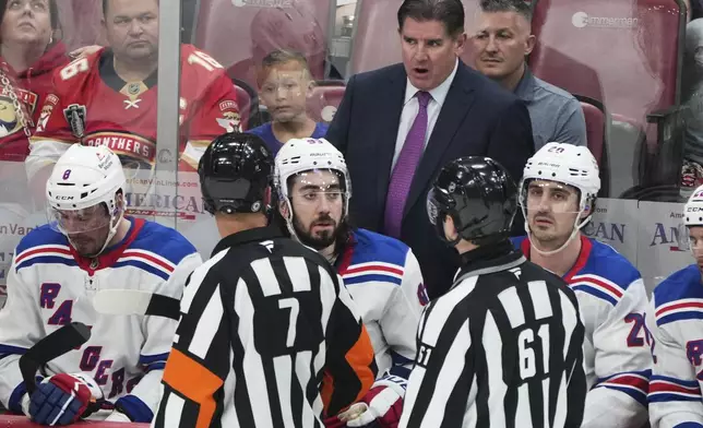 New York Rangers head coach Peter Laviolette, center, rear, talks with officials during the third period of an NHL hockey game against the Florida Panthers, Monday, April 14, 2025, in Sunrise, Fla. (AP Photo/Lynne Sladky)
