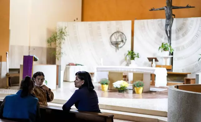 FILE - Transgender women, from left, Claudia Vittoria Salas, Andrea Paola Torres Lopez and Carla Segovia speak as they sit in the Beata Vergine Immacolata church in Torvaianica, Italy, on Nov. 16, 2023. (AP Photo/Andrew Medichini, File)