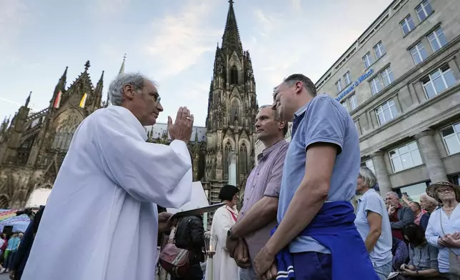 FILE - Same-sex couples take part in a public blessing ceremony in front of the Cologne Cathedral in Cologne, Germany, on Sept. 20, 2023. (AP Photo/Martin Meissner, File)