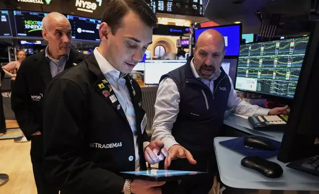 Specialist James Denaro, right, and trader Dylan Halvorsan, center, work on the floor of the New York Stock Exchange, Tuesday, April 22, 2025. (AP Photo/Richard Drew)