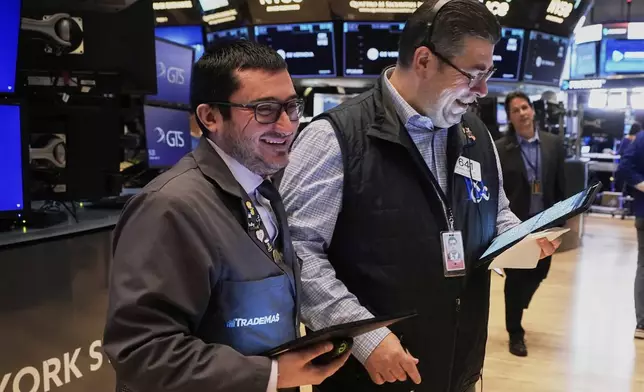 Traders Drew Cohen, left and Michael Capolino work on the floor of the New York Stock Exchange, Tuesday, April 22, 2025. (AP Photo/Richard Drew)