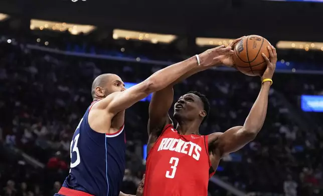 Houston Rockets center N'Faly Dante, right, shoots as Los Angeles Clippers forward Nicolas Batum defends during the first half of an NBA basketball game Wednesday, April 9, 2025, in Inglewood, Calif. (AP Photo/Mark J. Terrill)