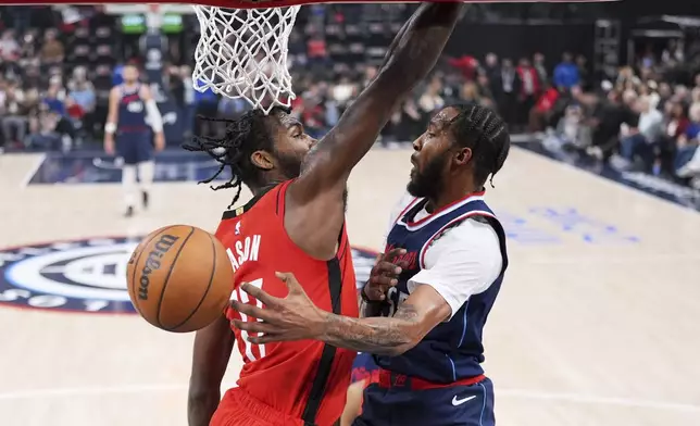 Los Angeles Clippers forward Derrick Jones Jr., right, passes the ball as Houston Rockets forward Tari Eason defends during the first half of an NBA basketball game Wednesday, April 9, 2025, in Inglewood, Calif. (AP Photo/Mark J. Terrill)