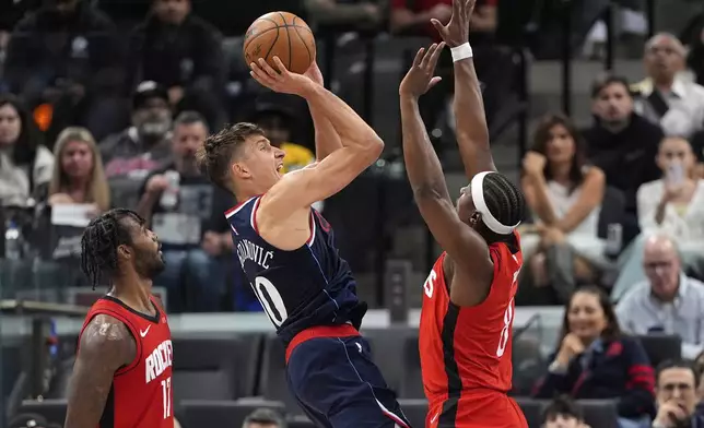 Los Angeles Clippers guard Bogdan Bogdanovic, center, shoots as Houston Rockets forward Tari Eason, left, and forward Jae'Sean Tate defend during the first half of an NBA basketball game Wednesday, April 9, 2025, in Inglewood, Calif. (AP Photo/Mark J. Terrill)