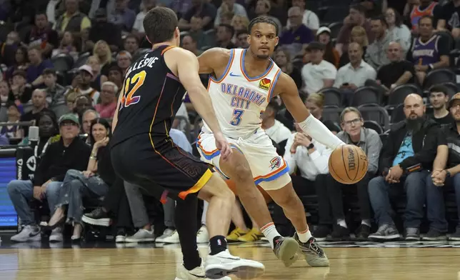 Oklahoma City Thunder forward Dillon Jones drives on Phoenix Suns guard Collin Gillespie (12) during the first half of an NBA basketball game, Wednesday, April 9, 2025, in Phoenix. (AP Photo/Rick Scuteri)