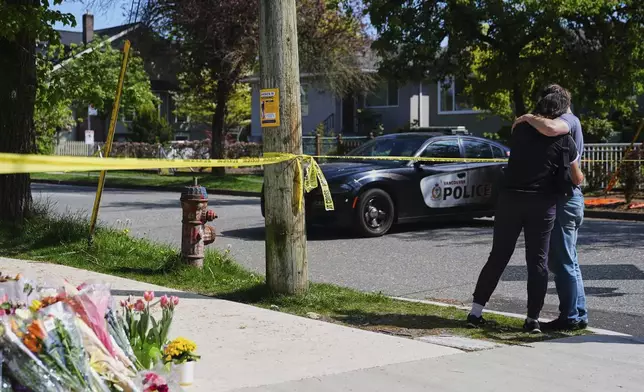 A couple hugs near the scene the day after a driver killed multiple people during a Filipino community festival Sunday, April 27, 2025, in Vancouver, British Columbia. (AP Photo/Lindsey Wasson)