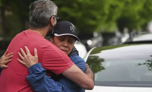 Esperanza Bermudez, right, who lives across the street from the scene, is comforted by friend Manjit Claire, left, the morning after a driver killed multiple people during a Filipino community festival Sunday, April 27, 2025, in Vancouver, British Columbia. (AP Photo/Lindsey Wasson)