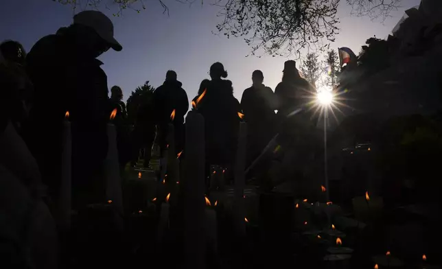 People pay their respects at a vigil at Kensington Park after a vehicle drove into a crowd during a Filipino heritage festival in Vancouver, British Columbia, Sunday, April 27, 2025. (AP Photo/Lindsey Wasson)