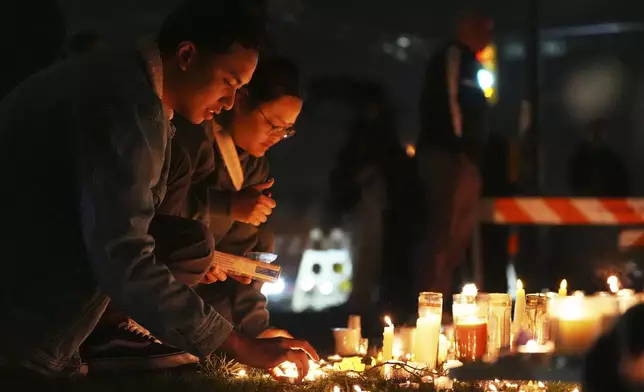 Wendell Gomez, left, and Justine Sta Rita visit a memorial for victims after a vehicle drove into a crowd during a Filipino heritage festival in Vancouver, British Columbia, Monday, April 28, 2025. (AP Photo/Lindsey Wasson)