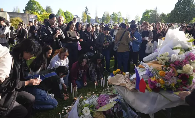 Attendees pay their respects during a vigil at Kensington Park after a vehicle drove into a crowd during a Filipino heritage festival in Vancouver, British Columbia, Sunday, April 27, 2025. (AP Photo/Lindsey Wasson)