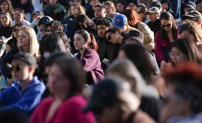 People listen to community members speak during a vigil for the victims after a vehicle drove into a crowd Saturday and killed multiple people at a Filipino heritage festival, in Vancouver, British Columbia, Sunday, April 27, 2025. (Darryl Dyck/The Canadian Press via AP)