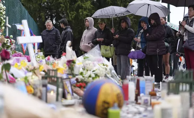 Attendees visit a memorial for victims after a vehicle drove into a crowd during a Filipino heritage festival in Vancouver, British Columbia, Monday, April 28, 2025. (AP Photo/Lindsey Wasson)
