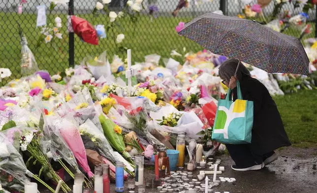 A woman visits a memorial for victims after a vehicle drove into a crowd during a Filipino heritage festival in Vancouver, British Columbia, Monday, April 28, 2025. (AP Photo/Lindsey Wasson)