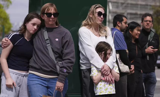 People view a growing memorial near the scene where a driver killed multiple people the previous day during a Filipino community festival Sunday, April 27, 2025, in Vancouver, British Columbia. (AP Photo/Lindsey Wasson)