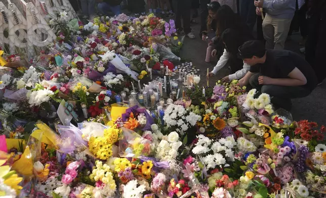 Visitors pay their respects at a memorial after a vehicle drove into a crowd during a Filipino heritage festival in Vancouver, British Columbia, Sunday, April 27, 2025. (AP Photo/Lindsey Wasson)