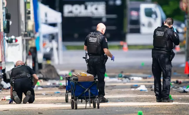 Members of the Vancouver Police forensics examine the evidence while investigating the scene where a vehicle drove into crowd at a street festival, in Vancouver, British Columbia, Sunday, April 27, 2025. (Rich Lam/The Canadian Press via AP)
